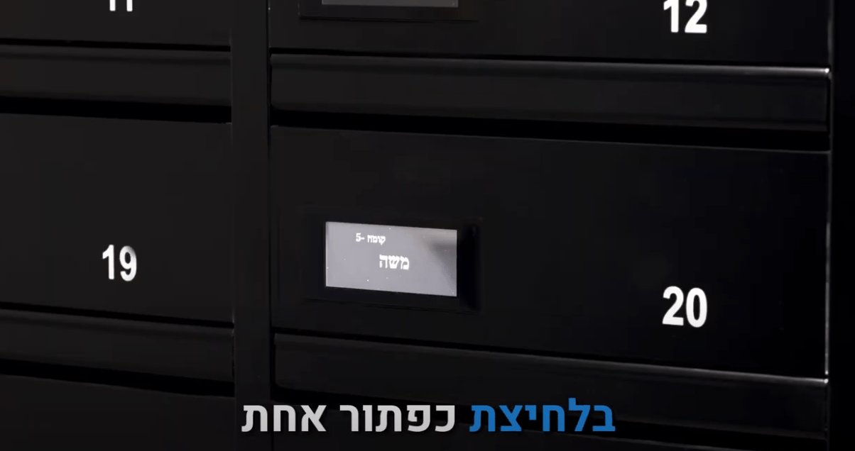 תיבות דואר שחורות עם מספרים לבנים, תיבה מספר 20 מציגה מסך דיגיטלי עם שם הדייר 'משה - קומה 5'. כיתוב בתחתית: 'בלחיצת כפתור אחת